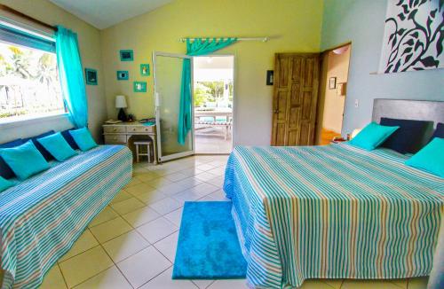 1 dormitorio con 2 camas y puerta a un patio en Villa Talanquera, en Las Galeras