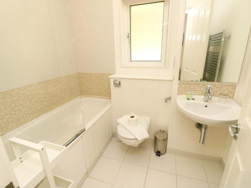 a bathroom with a tub and a toilet and a sink at Whitfield P1 in Yarmouth