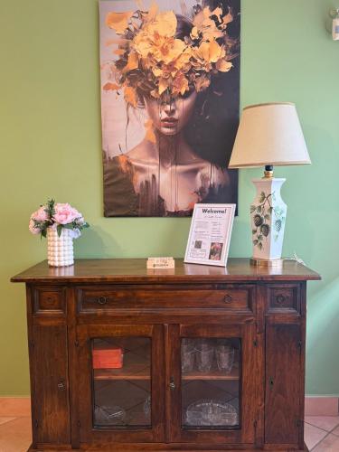 a table with a lamp and a painting on the wall at Casetta Romana Alloggio Turistico in Borghesiana 