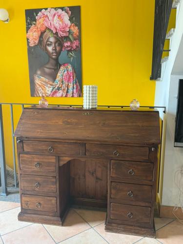 a wooden dresser with a painting of a woman at Casetta Romana Alloggio Turistico in Borghesiana 