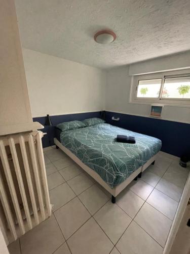 une chambre avec un lit dans une pièce avec une fenêtre dans l'établissement Séjour Confortable à la Villa Neptune 2 Chambres, à Biarritz