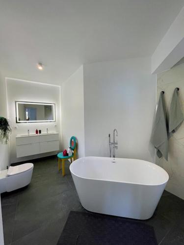 a large white bathroom with a tub and a tv at TheView in Funchal