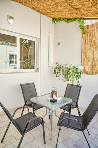 a glass table with four chairs and a window at Malona Nostalgia in Malona Village