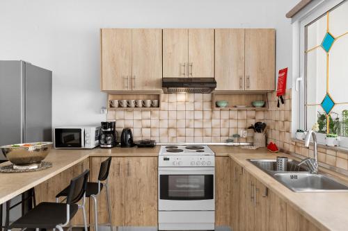 a kitchen with wooden cabinets and a white stove top oven at Malona Nostalgia in Malona Village