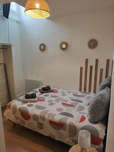 a bedroom with a bed with a comforter on it at L'esprit Cyrano in Bergerac