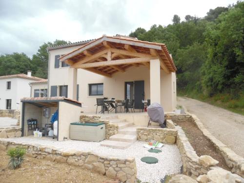 une petite maison avec un patio et une table dans l'établissement Coeur de Bonnieux, à Bonnieux