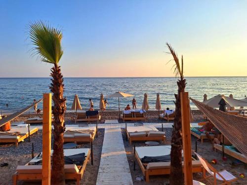 a beach with chairs and umbrellas and the ocean at Sea Whisper Apartment in Budva