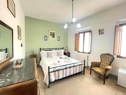 a bedroom with a bed and a chair at La Casa di Ines in San Gimignano