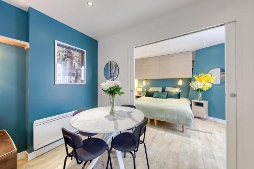 a room with a bed and a table with chairs at The CGT Elegance & Comfort at the Gates of Paris in Montreuil
