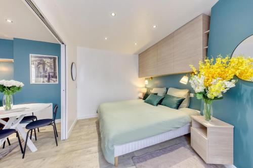 a bedroom with a bed and a table and a desk at The CGT Elegance & Comfort at the Gates of Paris in Montreuil