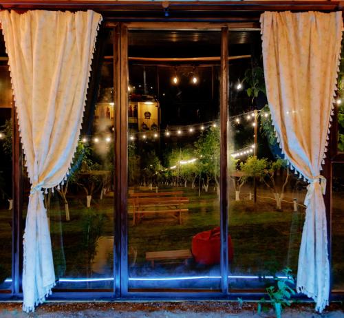 a window with curtains in front of a park at night at GreenField Resort in Yeghegnadzor