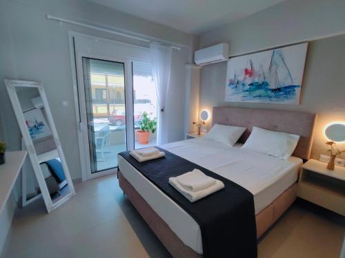 a bedroom with a large bed with two towels on it at mesogios enjoyable living in Kallithea Halkidikis