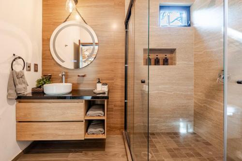 Un baño con ducha, lavabo y espejo. en Cabañas Cañada del Ciervo, en Mazamitla