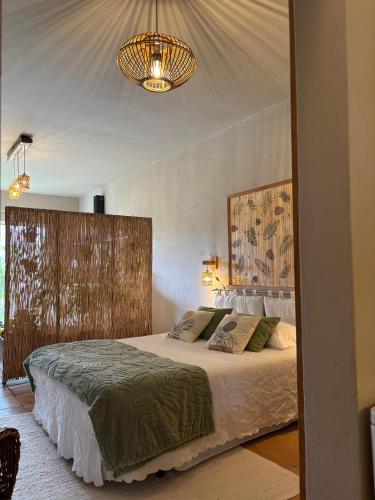 a bedroom with a large bed and a chandelier at Varanda de Coimbra in Penacova