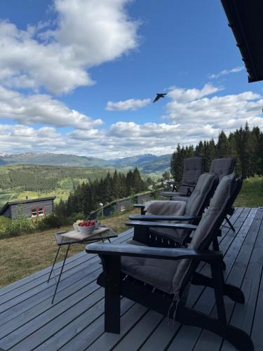 a group of chairs sitting on a deck with a view at Apartment with a view at Bavallen Tråstølen Voss in Vossevangen