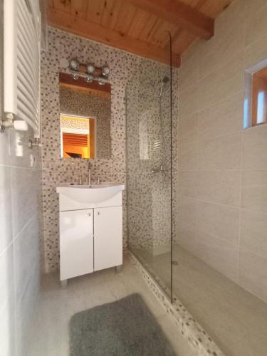 a bathroom with a shower and a white sink at Cabaña Nido del Bosque in San Carlos de Bariloche