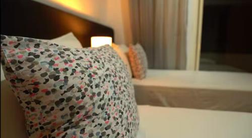 a pillow sitting on a bed next to a mirror at Chez Charifa in Asilah