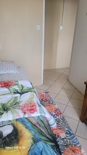 a bed with a floral comforter on top of it at Fano's Tropical Oasis, Boise D'orange ST Lucia in Castries