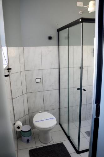 a bathroom with a toilet and a glass shower at Metro Hotel in Águas de Lindoia