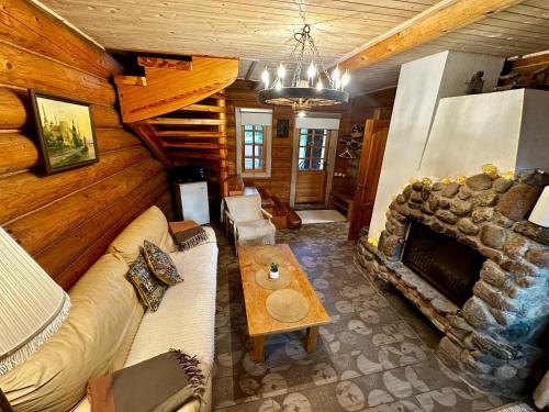 a living room with a couch and a fireplace at Brīvdienu māja Būmaņi in Dreiliņi