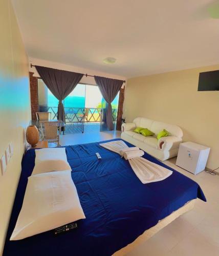a large blue bed in a room with a couch at Pousada do Toby in Canoa Quebrada
