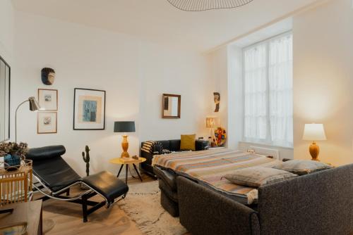 une chambre avec un lit et une chaise dans une pièce dans l'établissement Les Cactus #MaisonSavaron, à Clermont-Ferrand