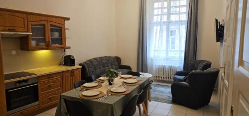 a living room with a table and chairs and a kitchen at Old Town Home Prague in Prague