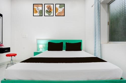 a bedroom with a large bed with a green headboard at Hotel O Online in Jāmul