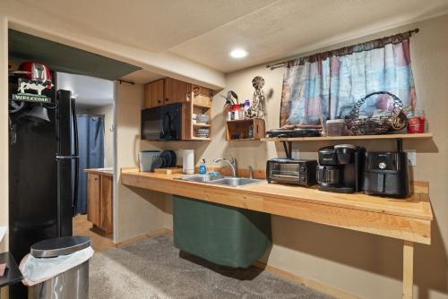 a kitchen with a counter with a sink and a refrigerator at Bo's Old West Den with Off Street Parking in Billings