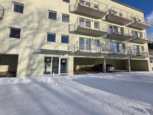 a snow covered parking lot in front of a building at Apartmán Maršovák Horní Maršov in Horní Maršov