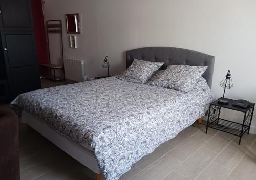 a bedroom with a bed with a gray headboard and pillows at Cocooning Studio de la Gare in Saint-André-de-Cubzac