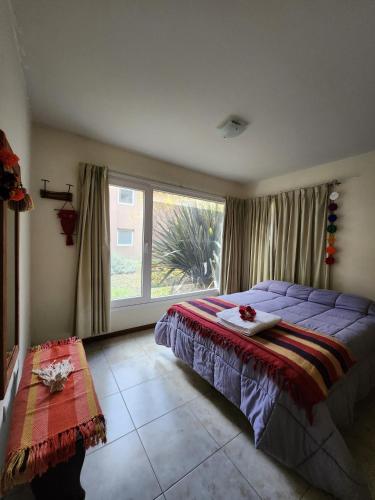 Un dormitorio con una cama y una ventana grande en Apartamento 1 Habitación RojoPatagonia, en San Martín de los Andes