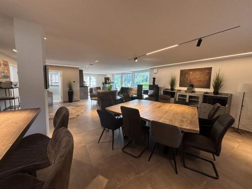 a dining room and living room with a table and chairs at Waldklang Panorama in Alpirsbach