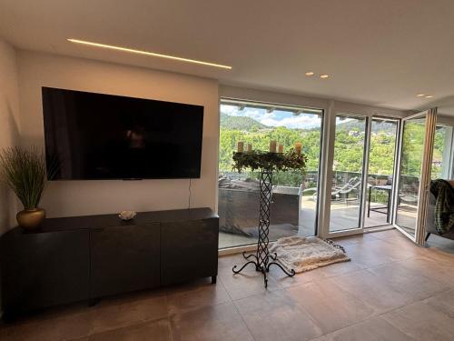 a living room with a flat screen tv on a wall at Waldklang Panorama in Alpirsbach