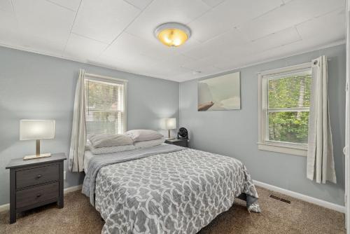 a bedroom with a bed and two windows at Bo's Cozy Green DADU Bungalow with shared Hot Tub, Sauna in Billings