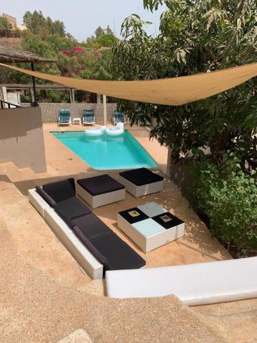 basen na podwórku ze stołem i krzesłami w obiekcie Villa Koté Océan w mieście Toubab Dialaw