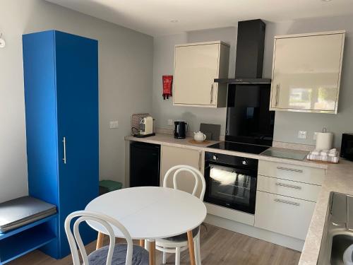 a small kitchen with a white table and chairs at Stagstone apartment in Fortrose in Fortrose