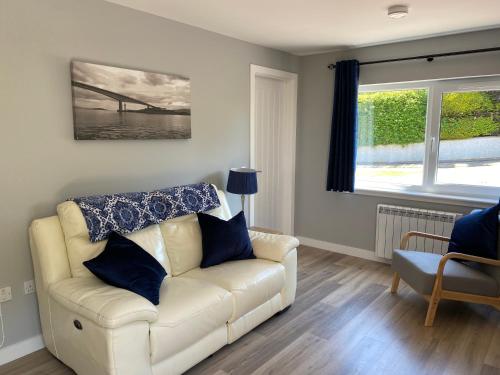 a living room with a white couch and a window at Stagstone apartment in Fortrose in Fortrose