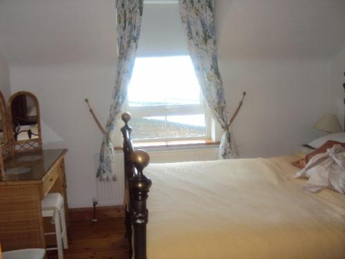 a bedroom with a bed and a large window at Sea View in Balnacart