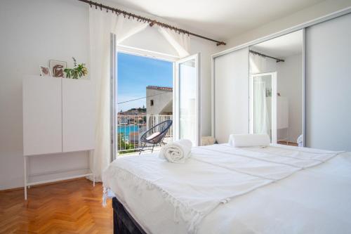 a bedroom with a large bed with a large window at Apartmani Ljubljeni in Primošten