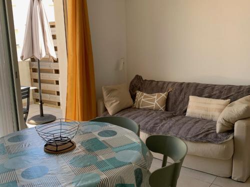 un salon avec une table et un canapé dans l'établissement Appartement T3 en Corse, Marina di Bravone N131, à Linguizzetta