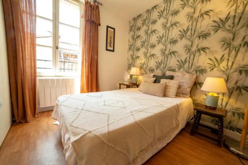 - une chambre avec un grand lit et du papier peint floral dans l'établissement Appartement Coeur d'Albi, à Albi