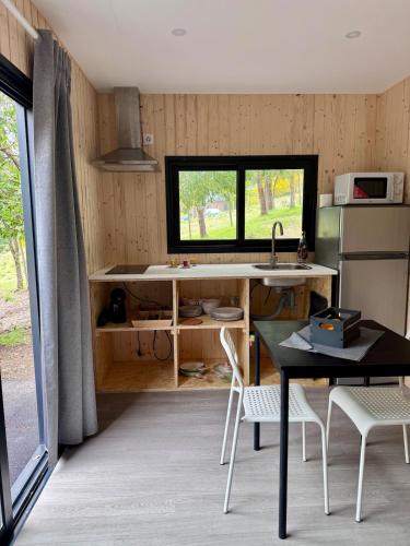 a kitchen with a sink and a table with chairs at Casa d' Além Turismo e Natureza - Refúgio do Bosque in Torneiro