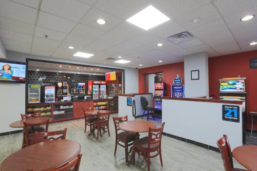 a restaurant with wooden tables and chairs and a counter at Days Inn by Wyndham Calumet Park in Calumet Park