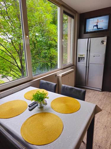 une cuisine avec une table avec des chaises et un réfrigérateur dans l'établissement Mladost Sofia, close to Metro Station and Center, à Sofia