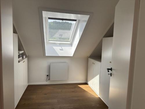 an attic room with a skylight and a window at Waldklang - Refugium Schwarzwald in Alpirsbach