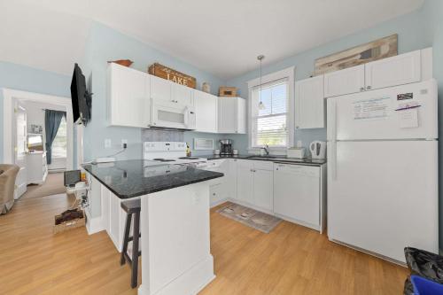 a kitchen with white cabinets and a white refrigerator at The Violet - 42 Meadow View in Cherry Valley