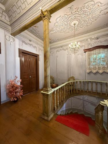 a large room with a staircase and a chandelier at Akkoç Heritage Suite by Lodhous in Ayvalık