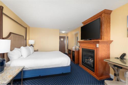 a hotel room with a bed and a flat screen tv at Fireside Inn, Ocean's Edge in Belfast