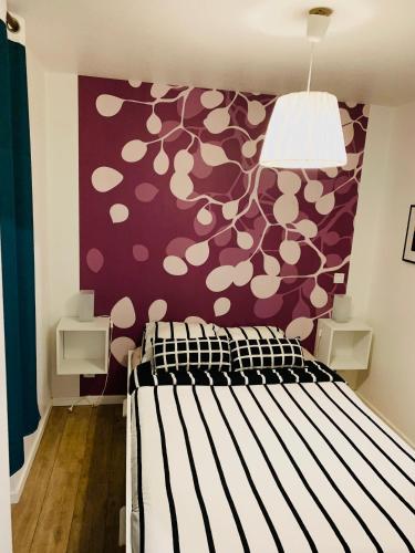 - une chambre avec un lit et un mur violet dans l'établissement Cosy appartement centre-ville Gare, à Strasbourg